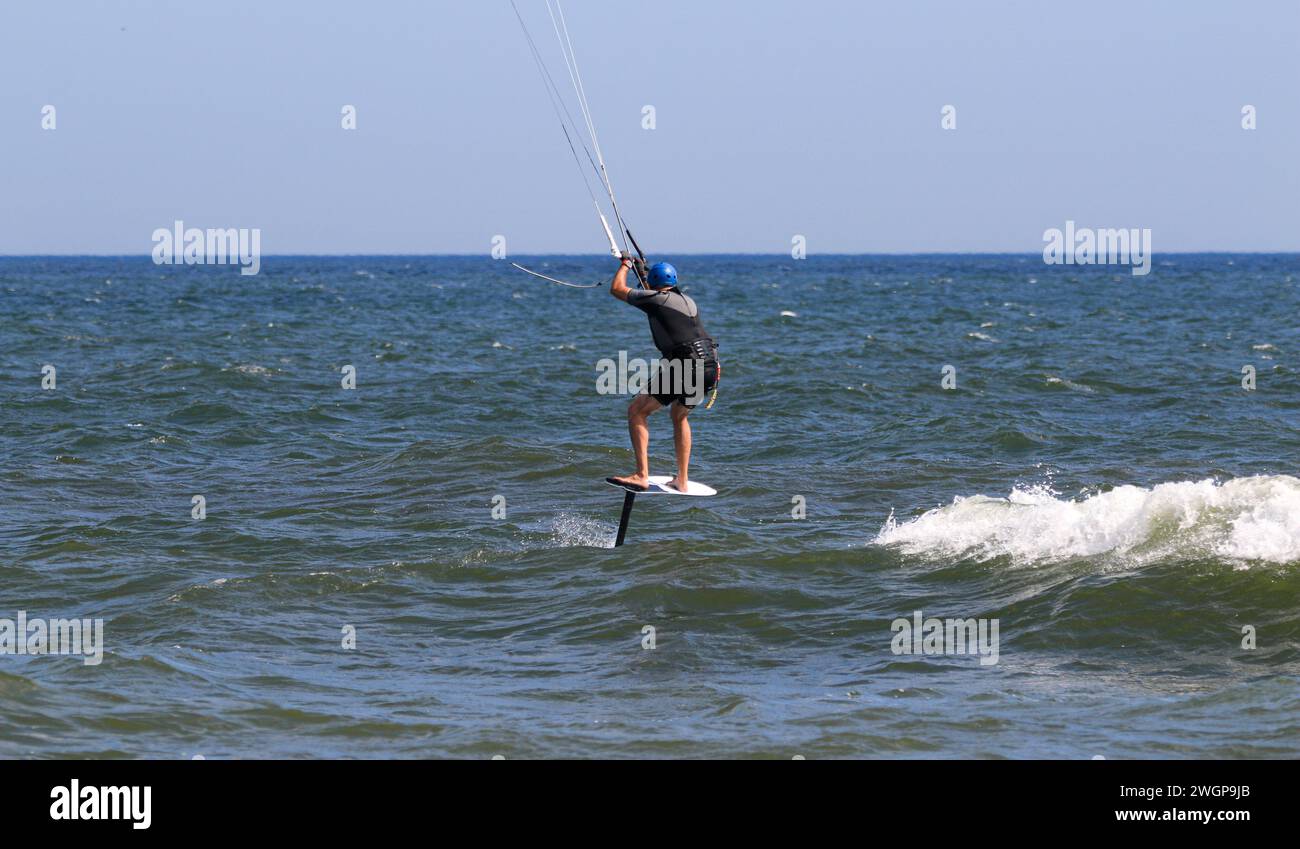 Un homme profitant d'un tour de kitesurf au-dessus de l'océan Atlantique au large de la côte de long Island. Banque D'Images