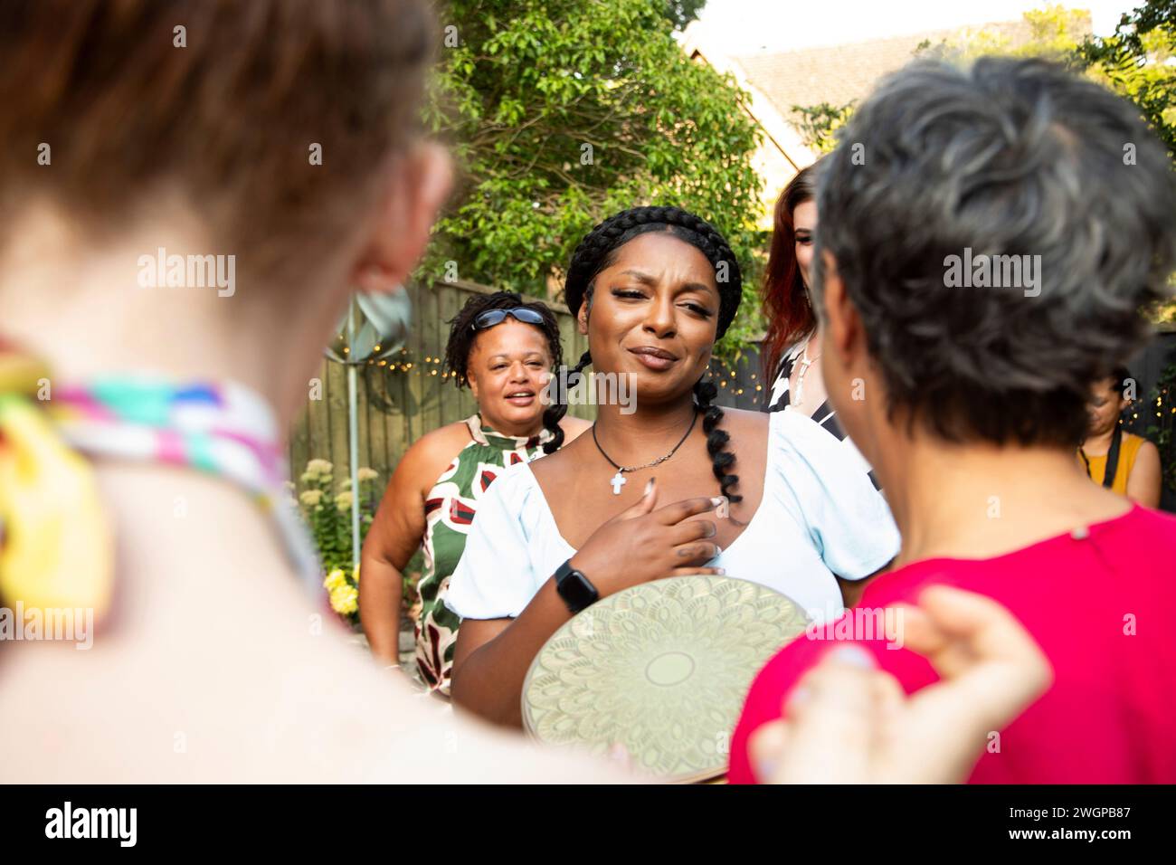 Amis et famille arrivant à une fête de jardin d'été Banque D'Images