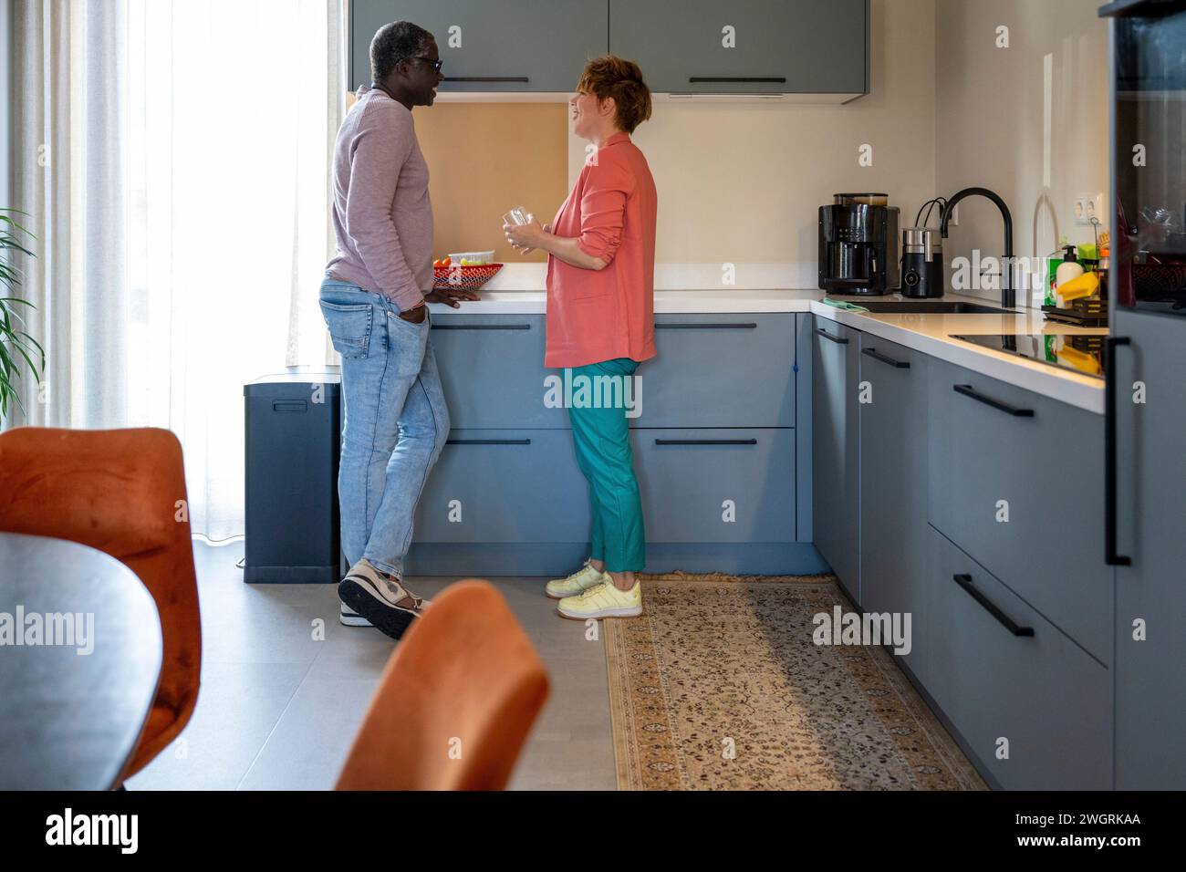Parents de race mixte dans la cuisine ayant une conversation intense Banque D'Images