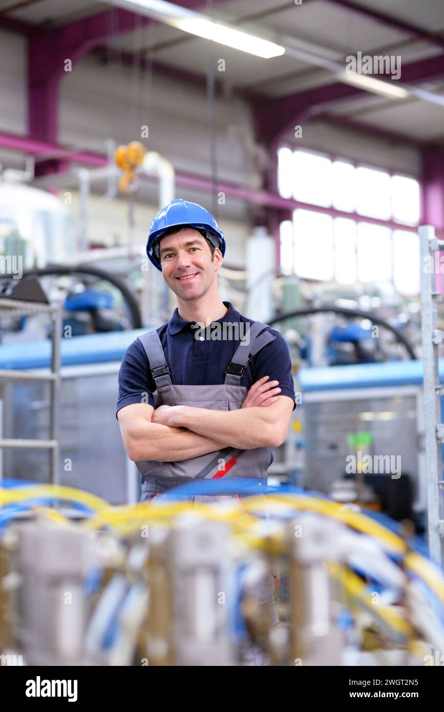 Portrait d'ouvrier dans une entreprise industrielle, en vêtements de travail sur le lieu de travail - libre Banque D'Images