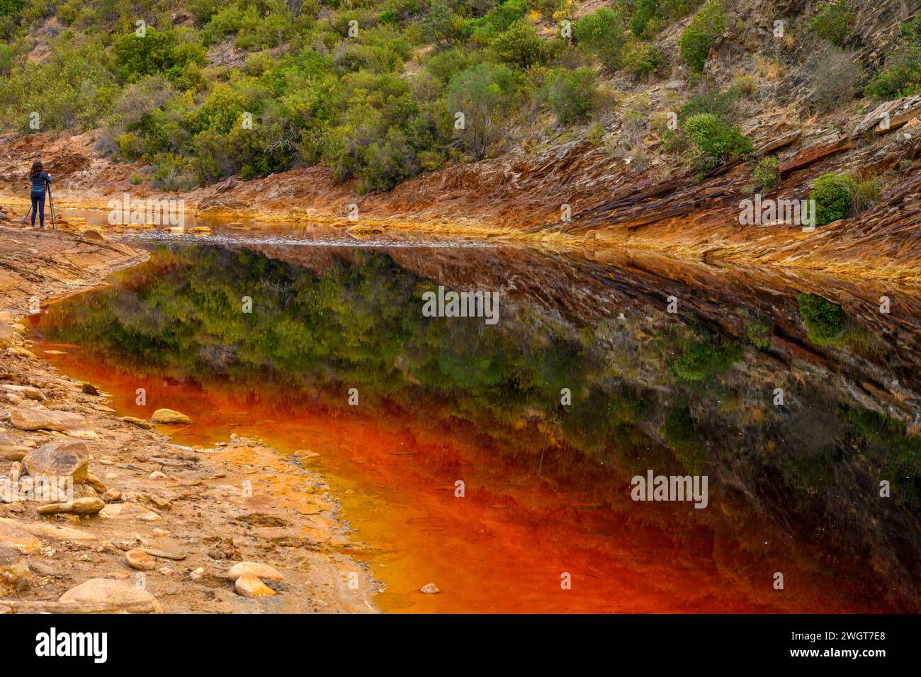 Des couches de terre frappantes et une strie vive d'eau rouge bordent le sol fissuré du Rio Tinto Banque D'Images