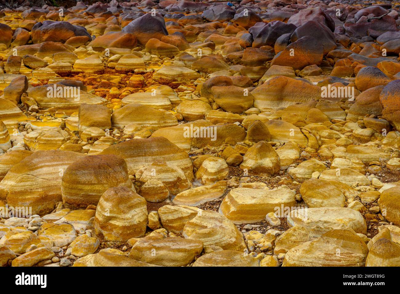 Les gisements minéraux oranges chauds de Rio Tinto sculptent un paysage texturé avec des flaques réfléchissantes Banque D'Images