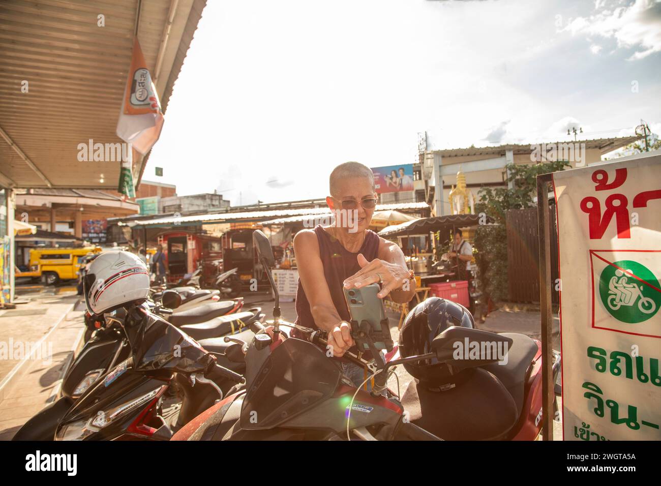 Femme mi-âgée voyageur solo se prépare à monter sur son scooter de location à Chiang mai Nord de la Thaïlande Banque D'Images