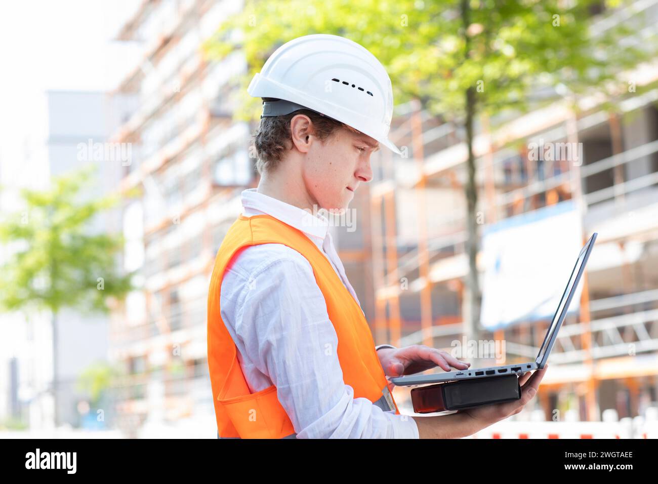 Ingénieur avec casque travaillant à l'extérieur d'un nouveau bâtiment Banque D'Images