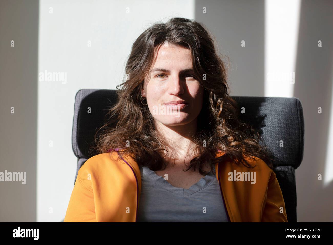 Jeune femme assise à la maison dans son bureau au soleil Banque D'Images