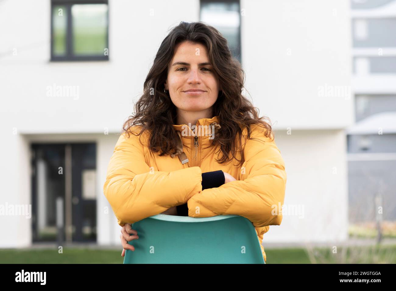 jeune femme sur une chaise devant sa maison Banque D'Images