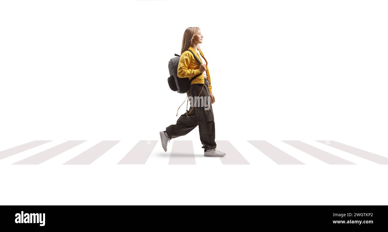 Étudiante adolescente avec un sac à dos marchant sur un passage piétonnier isolé sur fond blanc Banque D'Images