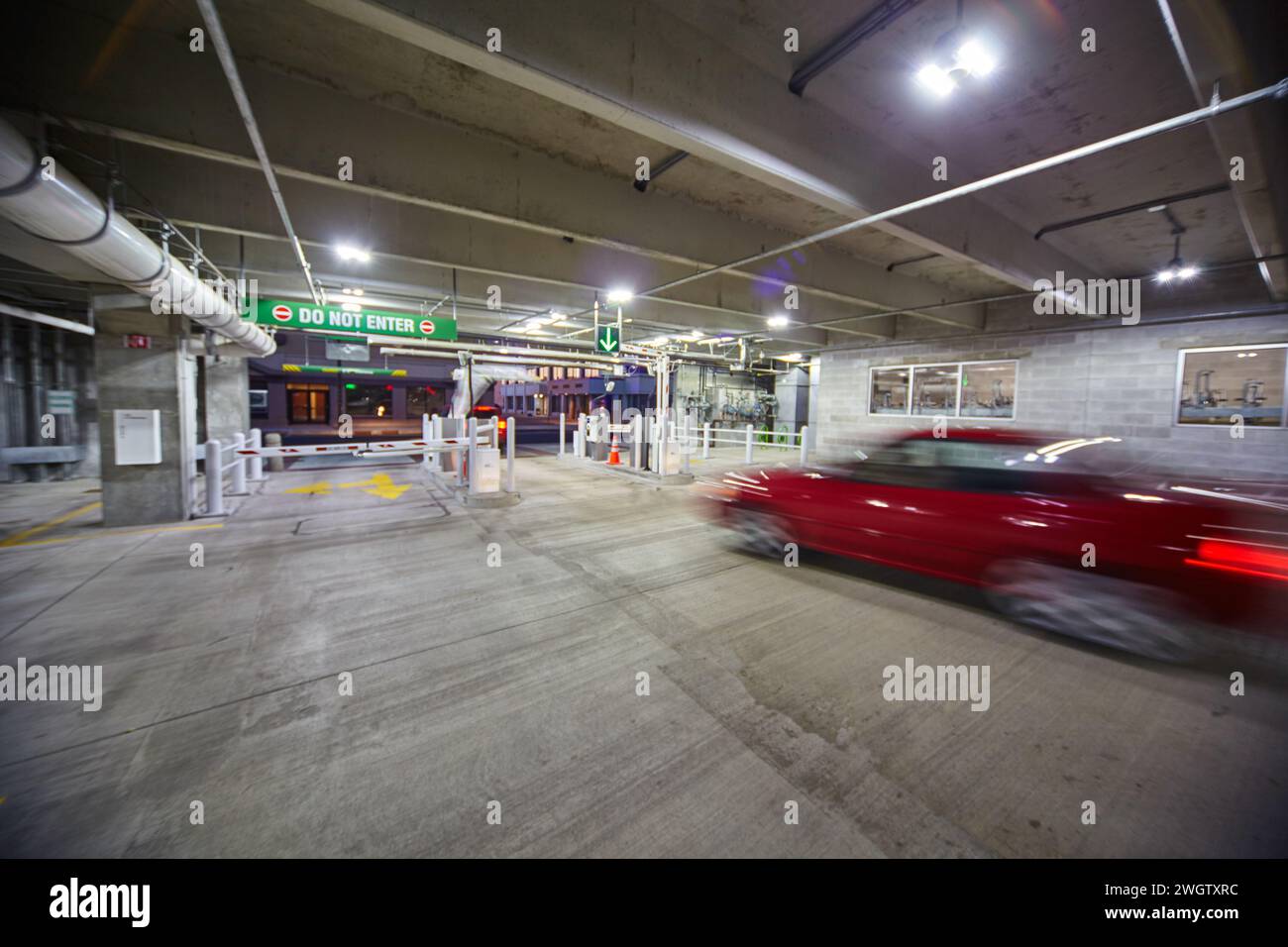 Vitesse de voiture rouge dans le garage de stationnement avec lumière verte - vue à angle bas Banque D'Images