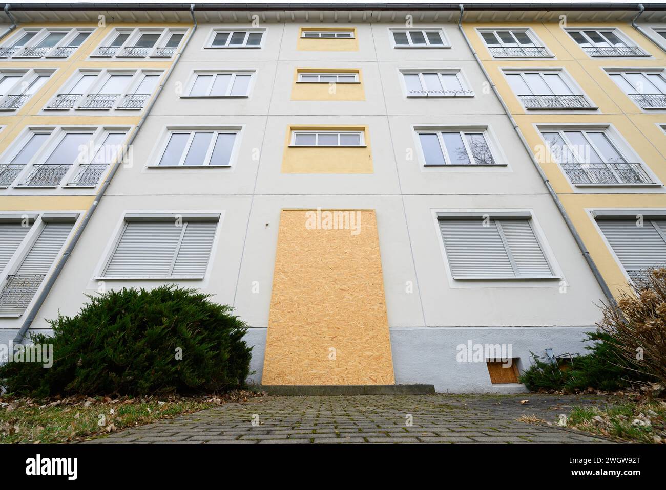 Hoyerswerda, Allemagne. 06th Feb, 2024. Une entrée du bloc d'appartements sur Brigitte-Reimann-Straße dans le complexe résidentiel I (WK I) est fermée par des panneaux de bois. L'association municipale de logement prévoit de démolir deux blocs dans le quartier. Crédit : Robert Michael/dpa/Alamy Live News Banque D'Images