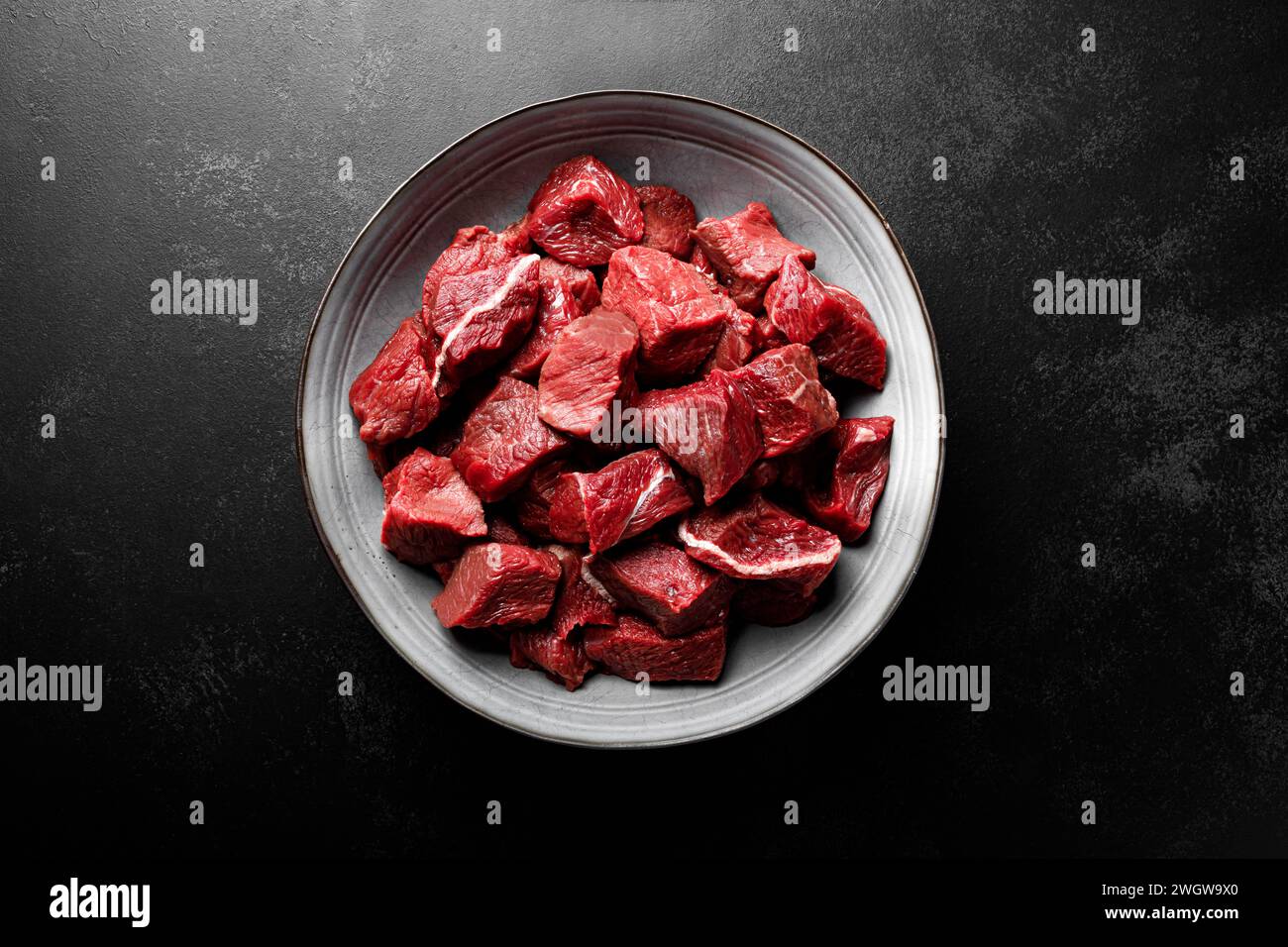 Entrecôte de viande de boeuf tranchée, filet de viande de boeuf crue sur fond noir, vue de dessus Banque D'Images