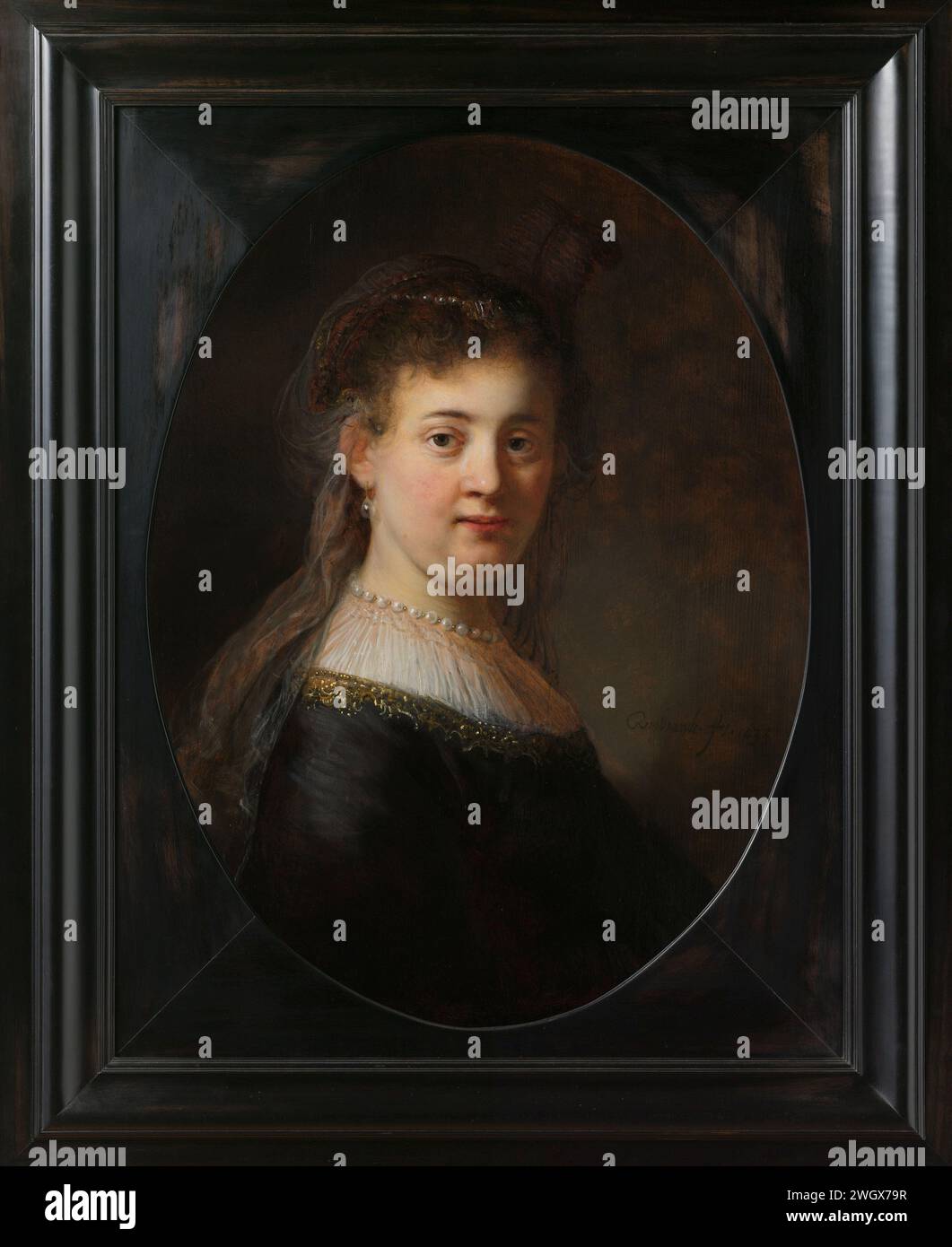 Jeune femme en costume fantaisie, Rembrandt van Rijn, 1633 peinture Portrait d'une femme, probablement l'épouse de Rembrandt Saskia van Uylenburgh (1612-1642). Buste à droite, le visage considéré. Un voile mince sur les cheveux, avec des boucles d'oreilles de perles et un collier de perles autour du cou. panneau. Peinture à l'huile (peinture) personnes historiques - BB - femme. équipement de cou : col (+ vêtements pour femmes). perles ; collier de perles (+ vêtements pour femmes) Banque D'Images