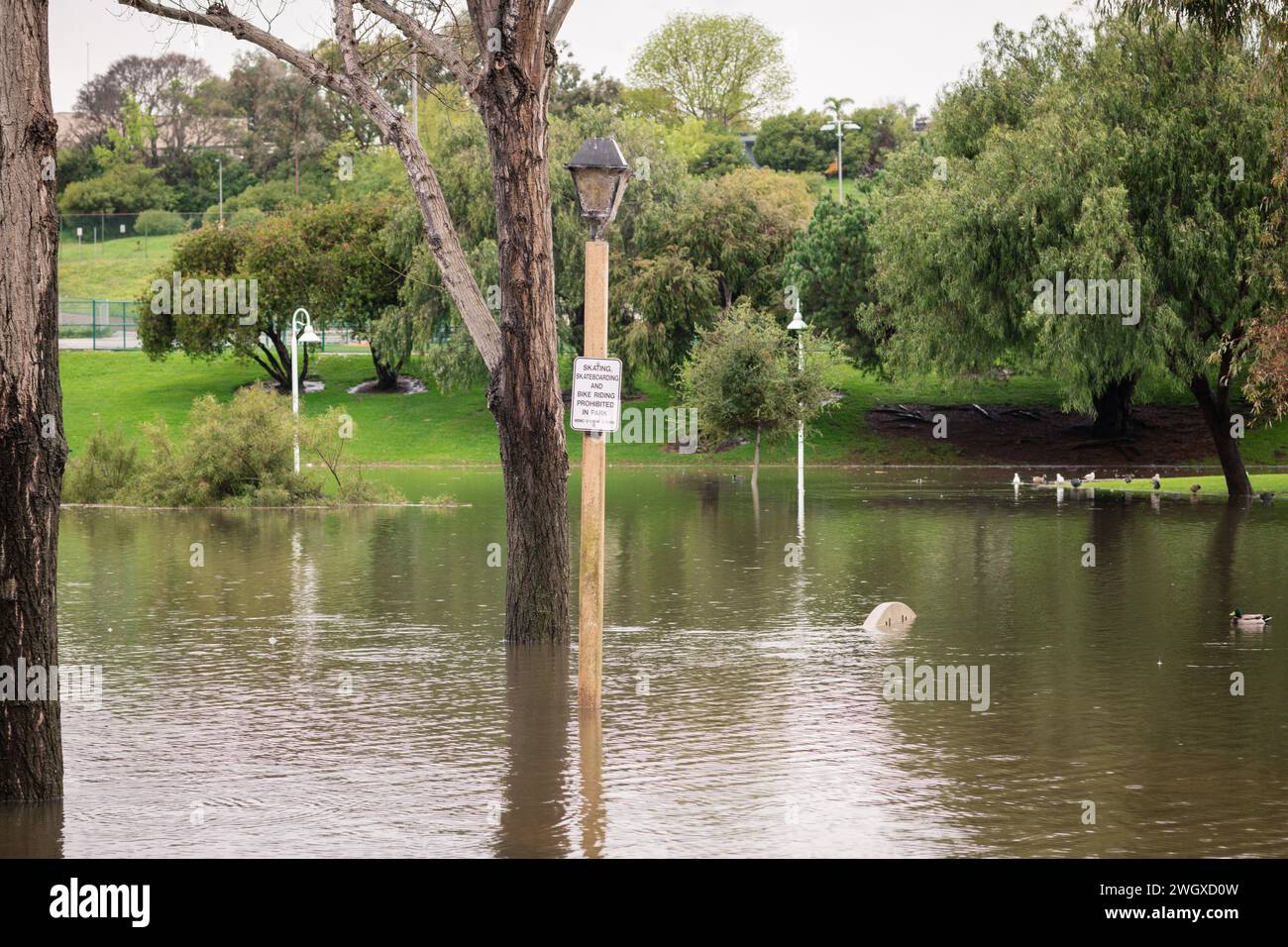 Terrain de jeu inférieur et grand étang au parc Polliwog inondé par la pluie à Manhattan Beach, CA Banque D'Images