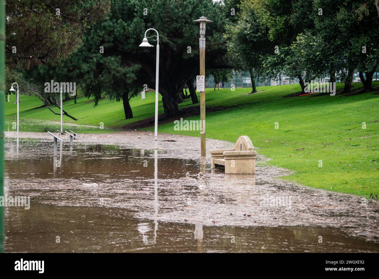 Terrain de jeu inférieur et grand étang au parc Polliwog inondé par la pluie à Manhattan Beach, CA Banque D'Images