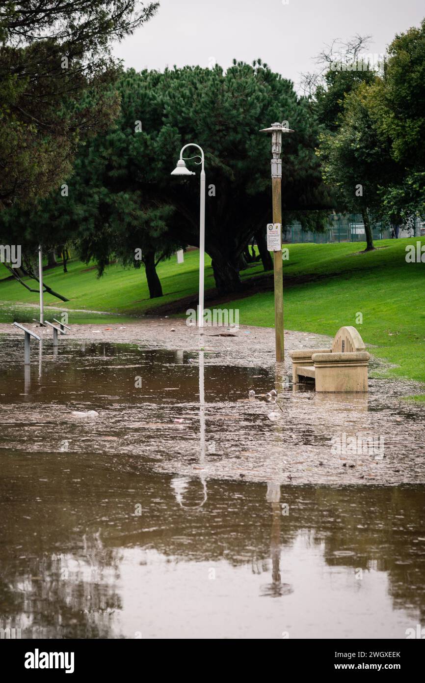 Terrain de jeu inférieur et grand étang au parc Polliwog inondé par la pluie à Manhattan Beach, CA Banque D'Images