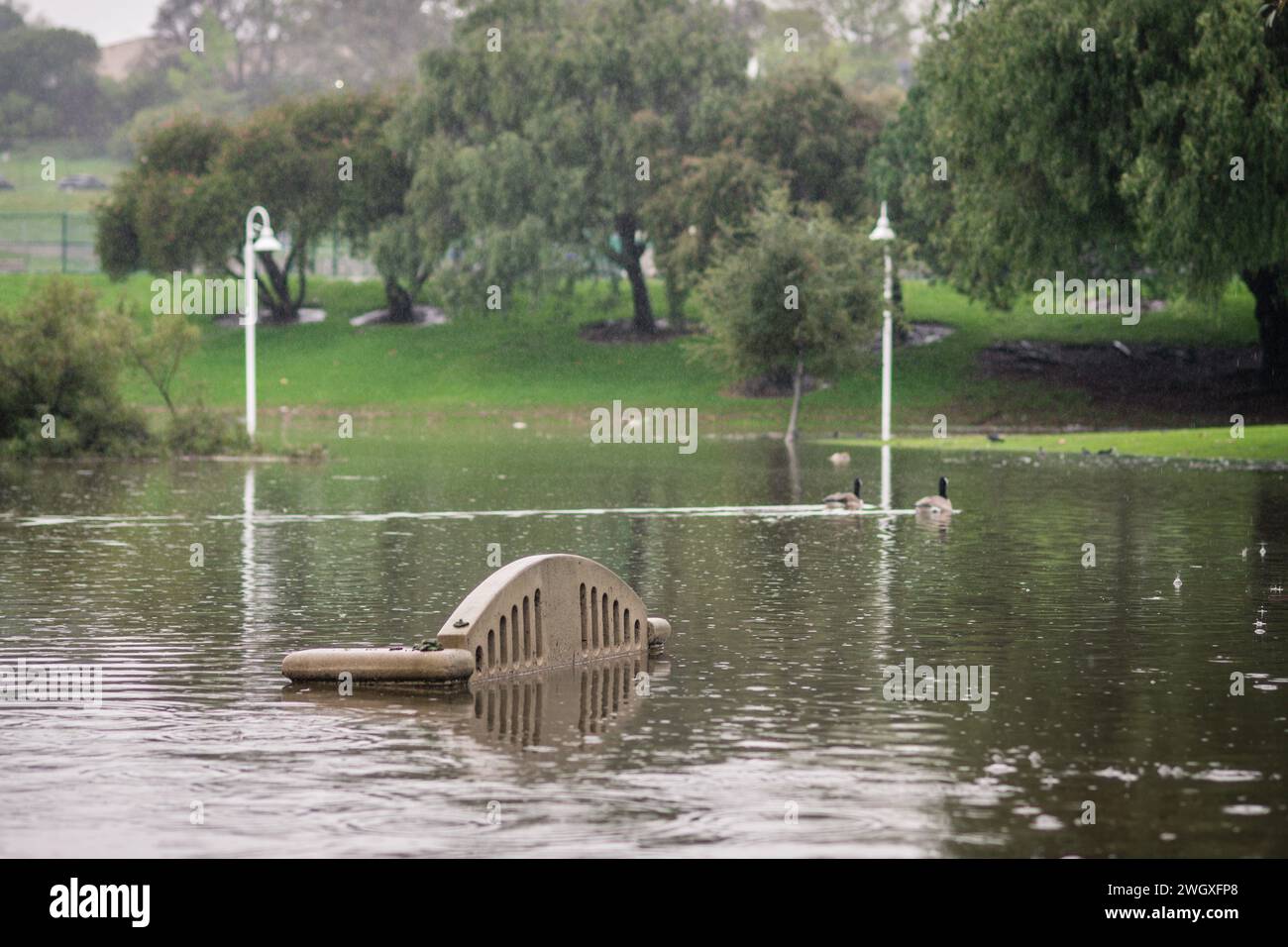 Terrain de jeu inférieur et grand étang au parc Polliwog inondé par la pluie à Manhattan Beach, CA Banque D'Images