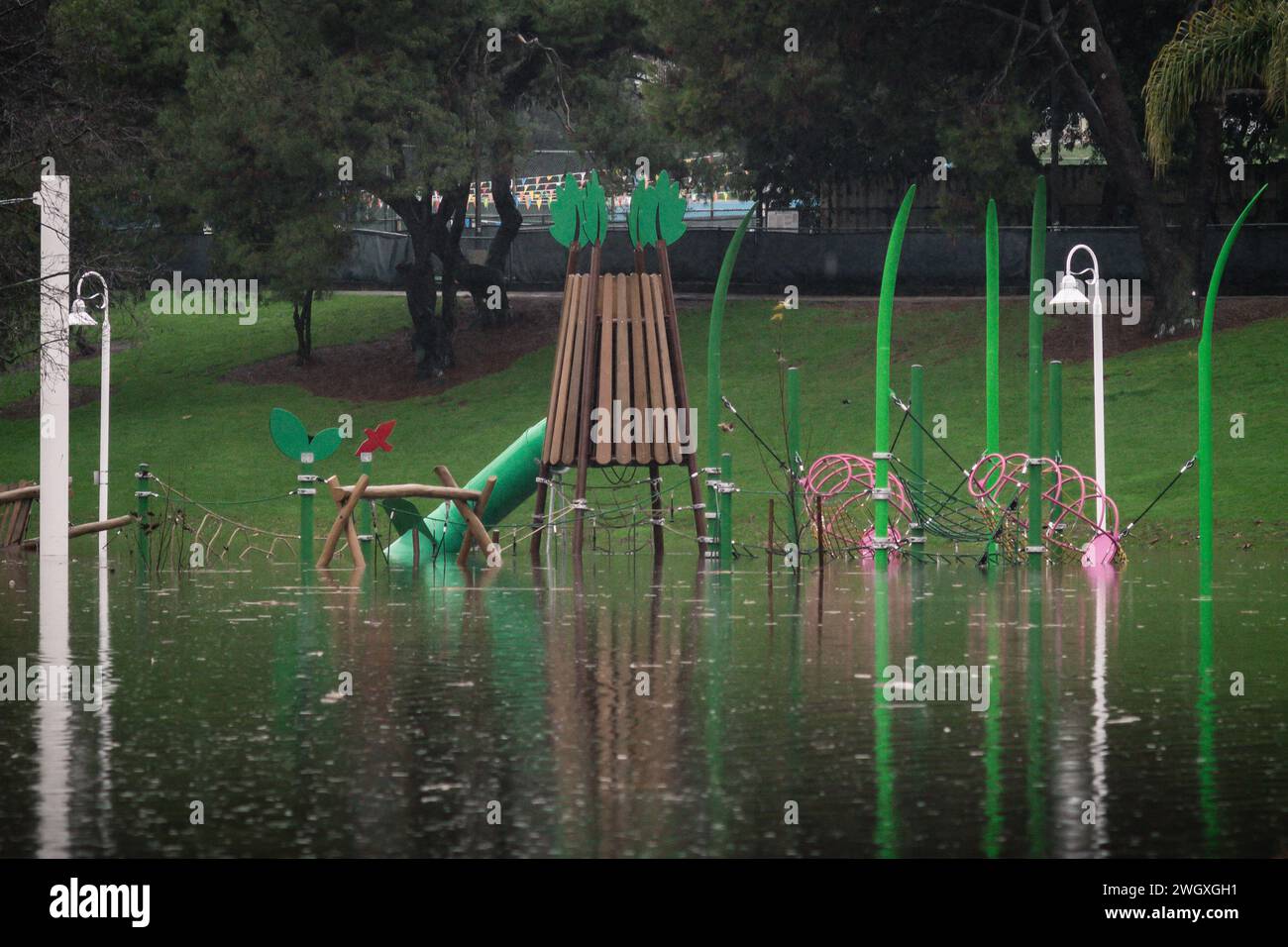 Terrain de jeu inférieur et grand étang au parc Polliwog inondé par la pluie à Manhattan Beach, CA Banque D'Images