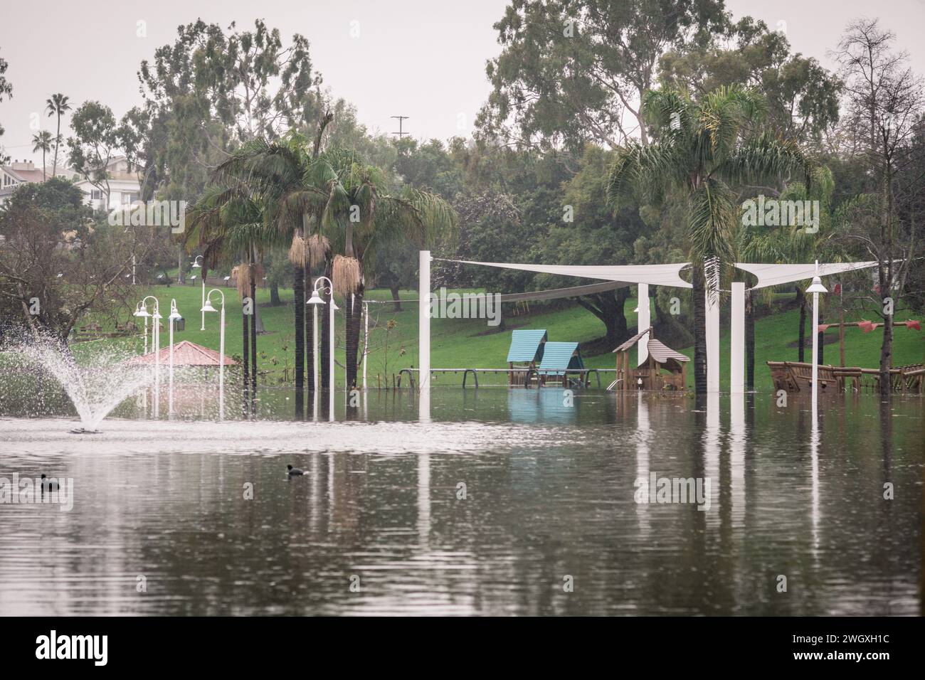 Terrain de jeu inférieur et grand étang au parc Polliwog inondé par la pluie à Manhattan Beach, CA Banque D'Images