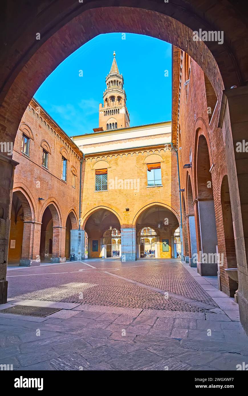 La vue à travers l'arche sur la petite Piazzale Federico II di Svevia dans la cour du Palazzo del Comune, Crémone, Italie Banque D'Images