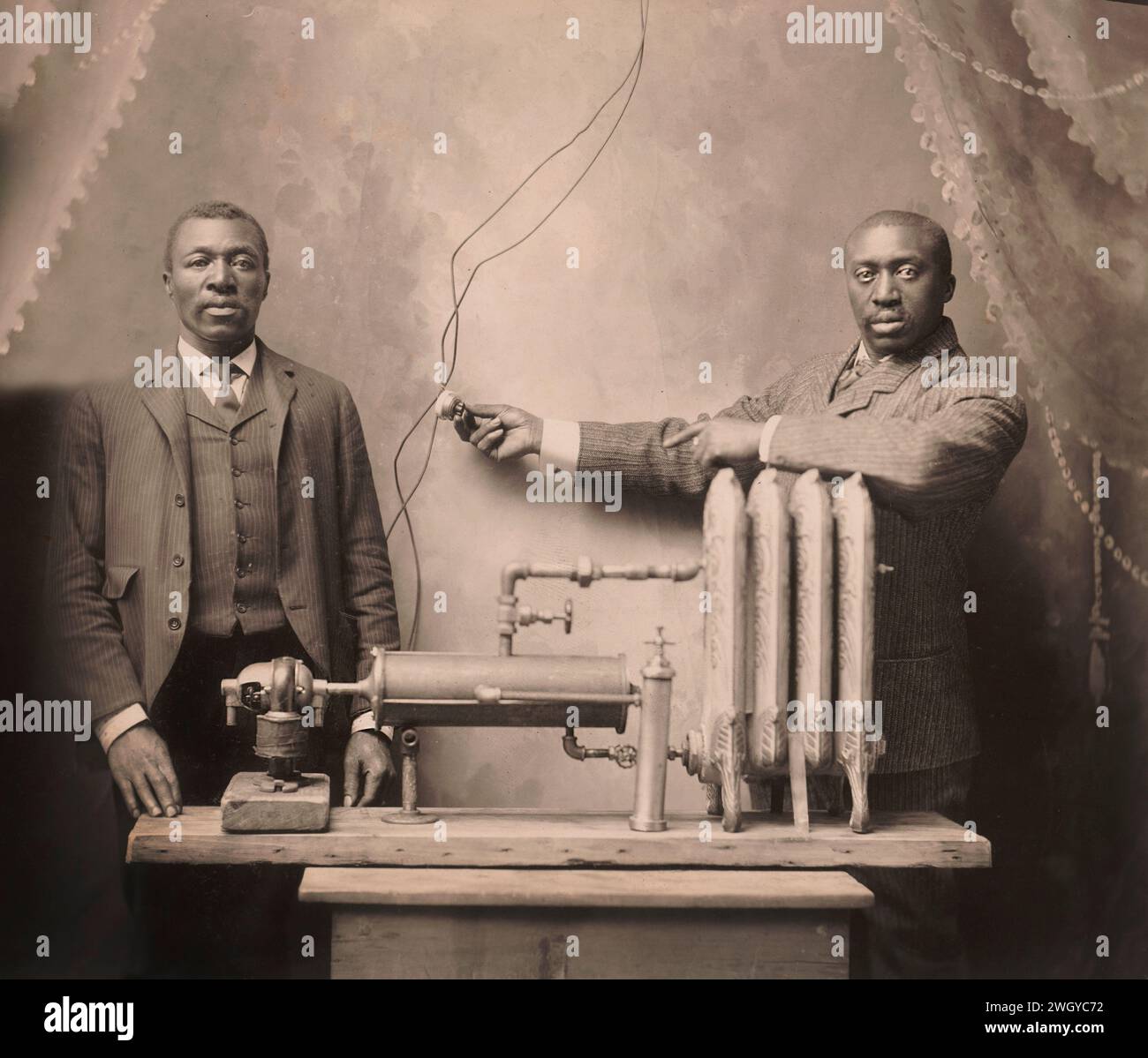 Inventeur américain Charles S.L. Baker (à droite), debout derrière le radiateur de chauffage, système, Martin W. Bode, 1906 Banque D'Images
