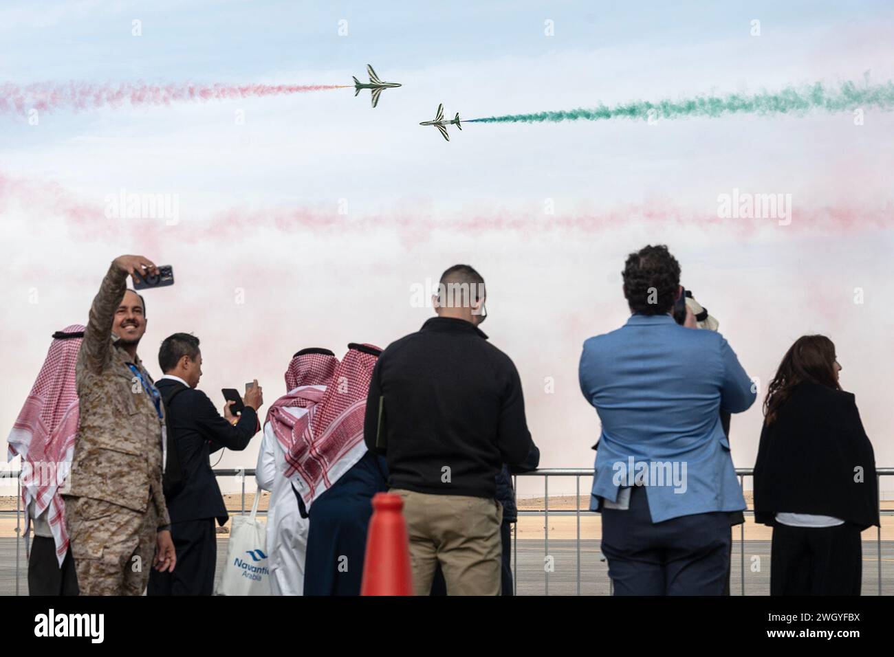 Les spectateurs regardent l'équipe de voltige de la Royal Saudi Air Force, les Saudi Hawks, se produire pendant le salon saoudien de la Défense mondiale près de Riyad, en Arabie Saoudite, le 5 février 2024. Le WDS 2024 de l’Arabie saoudite, l’une des plus grandes expositions de défense de la région, comprend un large éventail d’avions et d’actifs provenant de tout le département américain de la Défense. L’engagement des États-Unis en personnel et en avions dans la WDS saoudienne souligne l’importance de la poursuite de la coopération en matière de défense entre les alliés et les partenaires ayant une vision commune pour une paix et une stabilité durables dans la région. (Photo de l'US Air Force Banque D'Images
