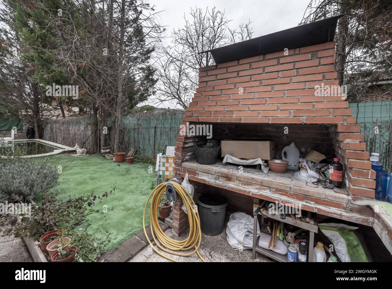 Un barbecue en brique à l'extérieur d'une propriété avec une piscine Banque D'Images