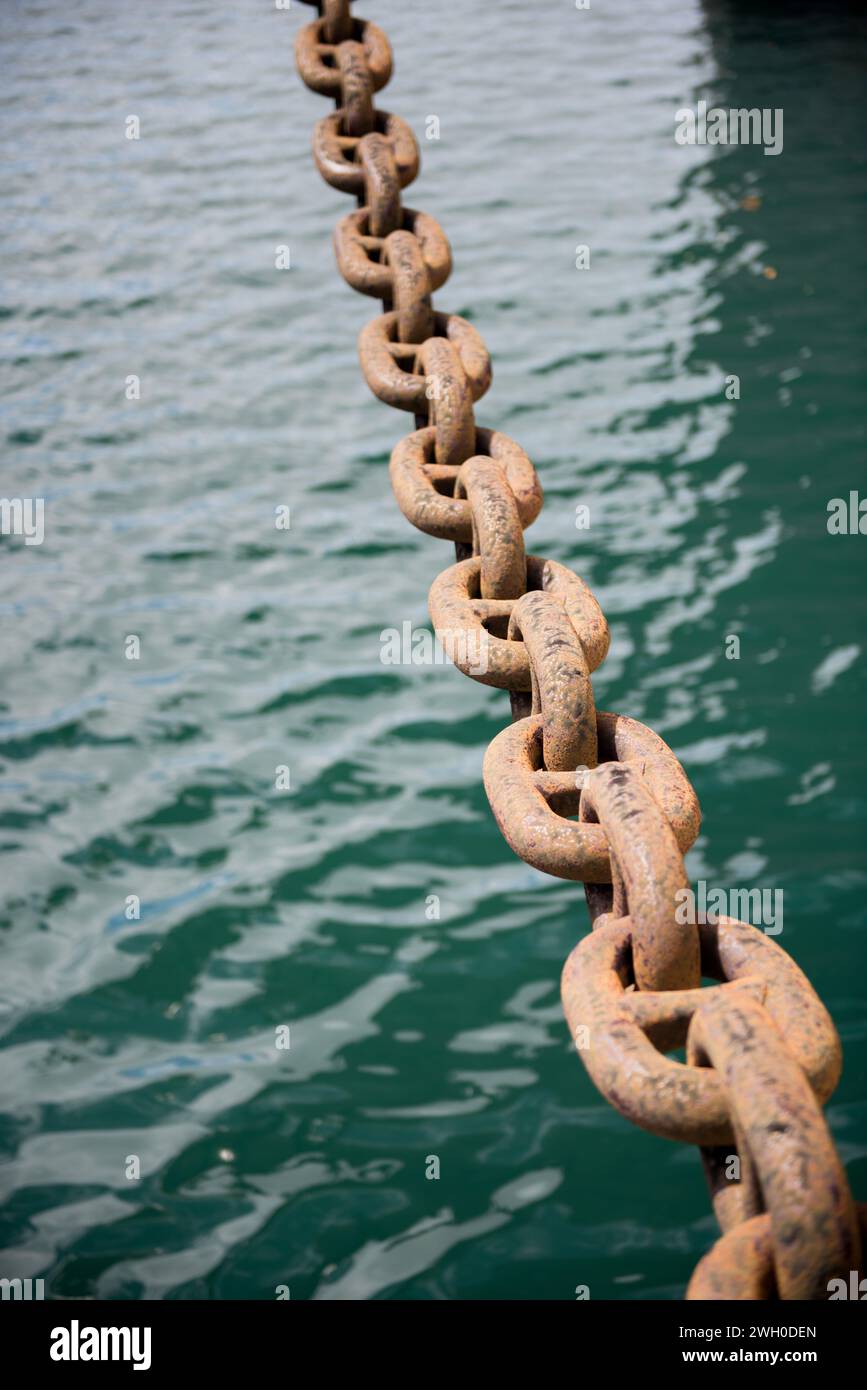 Ancre de chaîne de navire rouillé dans le fond abstrait d'eau de mer. Banque D'Images