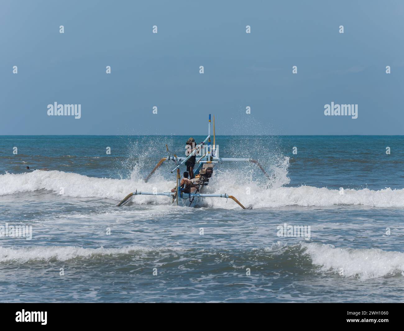 Bali, Indonésie - 22 octobre 2017 : bateau de pêche traditionnel indonésien avec stabilisateurs quittant la plage de Medewi sur l'île de Bali en Indonésie Banque D'Images