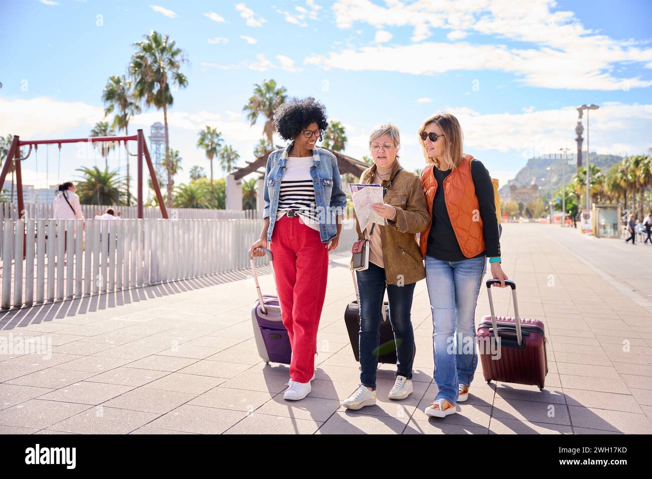 Groupe mature divers touristes autonomisés femmes amis marchant avec leurs bagages à la recherche de la carte de voyage. Banque D'Images