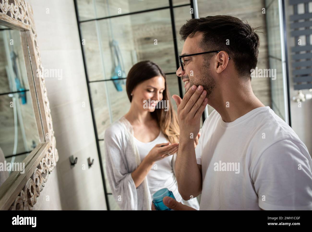 Couple passant par la routine matinale dans la salle de bain. Banque D'Images