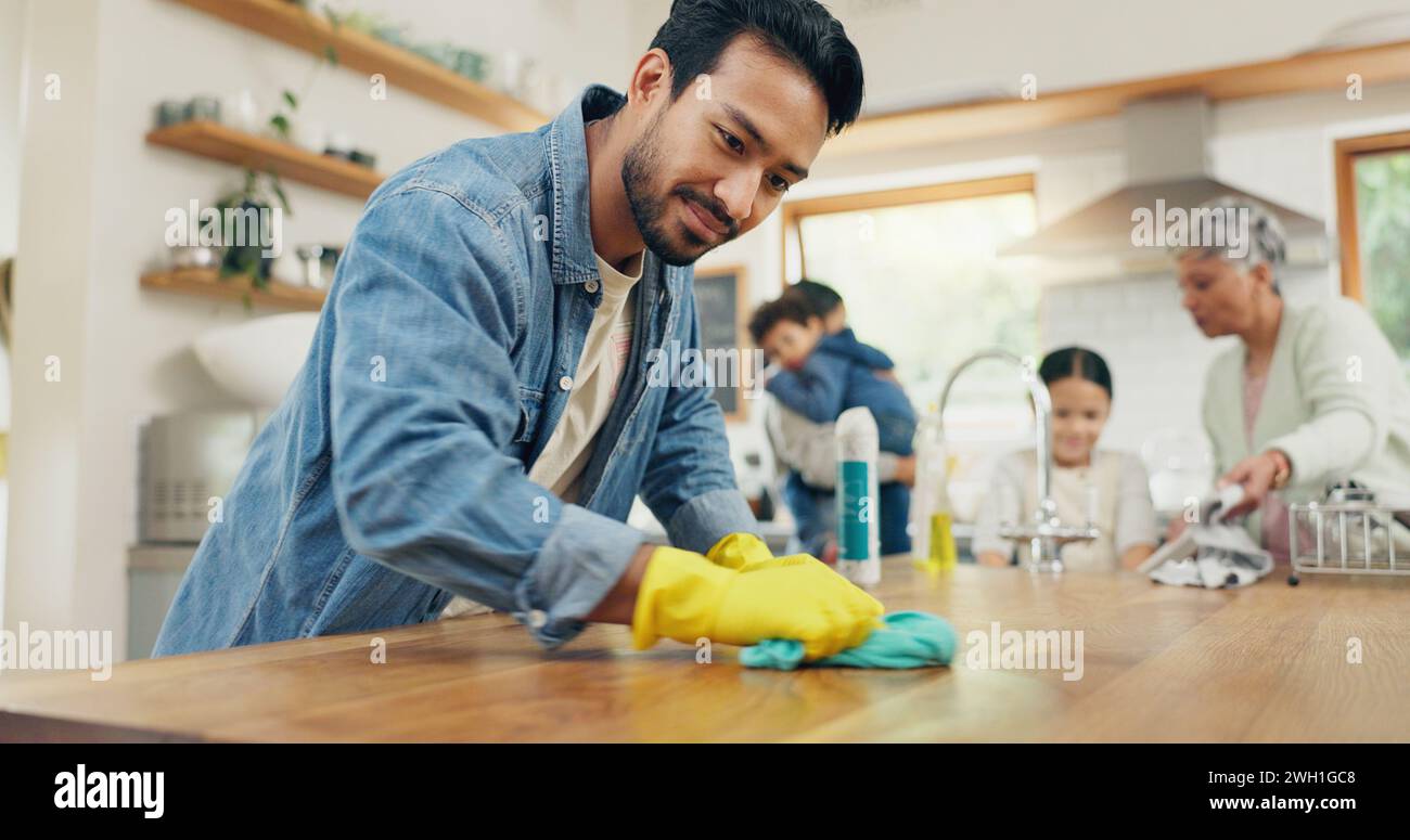 Famille, nettoyage et homme dans une cuisine avec tissu pour la table, l'hygiène ou l'espace de vie propre après le dîner. Maison, désinfection et Guy parent avec Banque D'Images