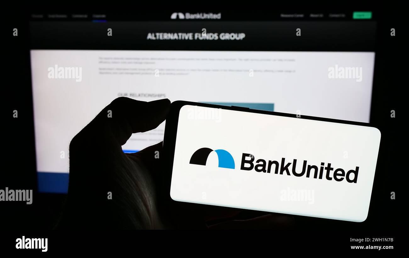 Personne tenant un smartphone avec le logo de la société américaine de services financiers BankUnited Inc en face du site Web. Concentrez-vous sur l'affichage du téléphone. Banque D'Images