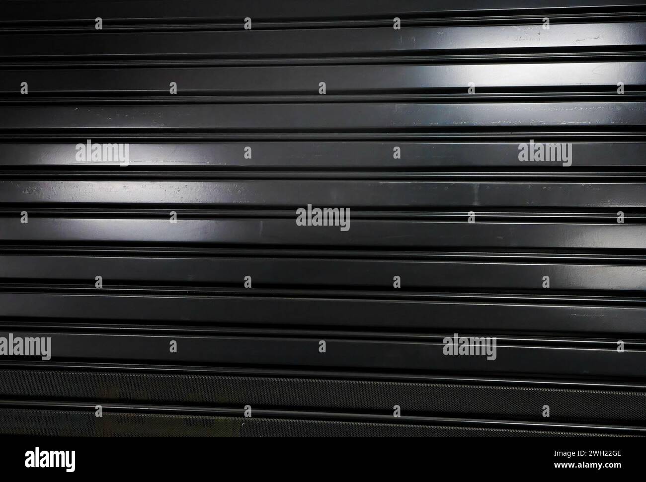 Partie de la porte métallique fermée. Noir et blanc, monochrome. ECLAIRAGE de forme abstraite par néon. Banque D'Images