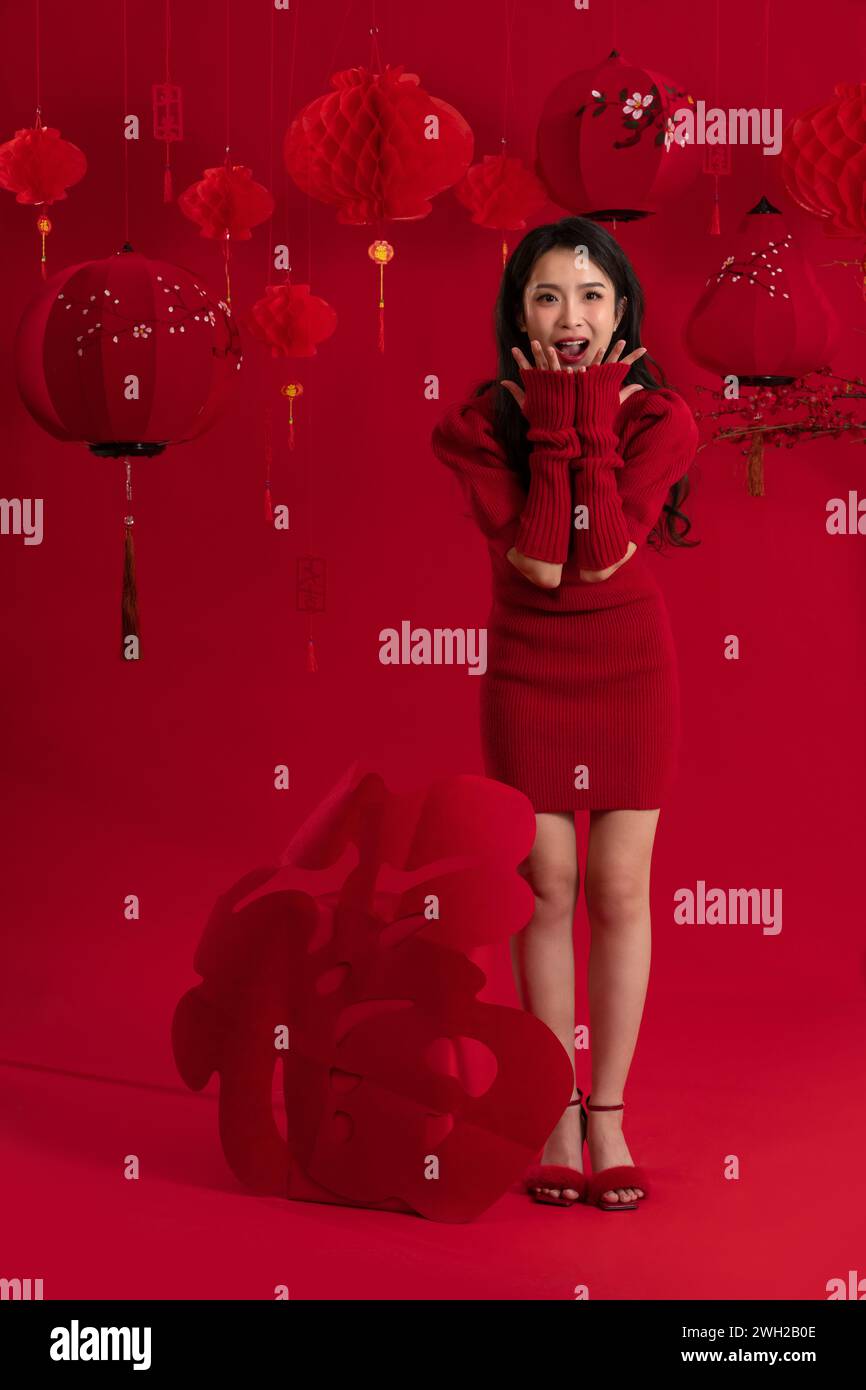 Ambiance du nouvel an, une jeune femme asiatique sur fond rouge Banque D'Images