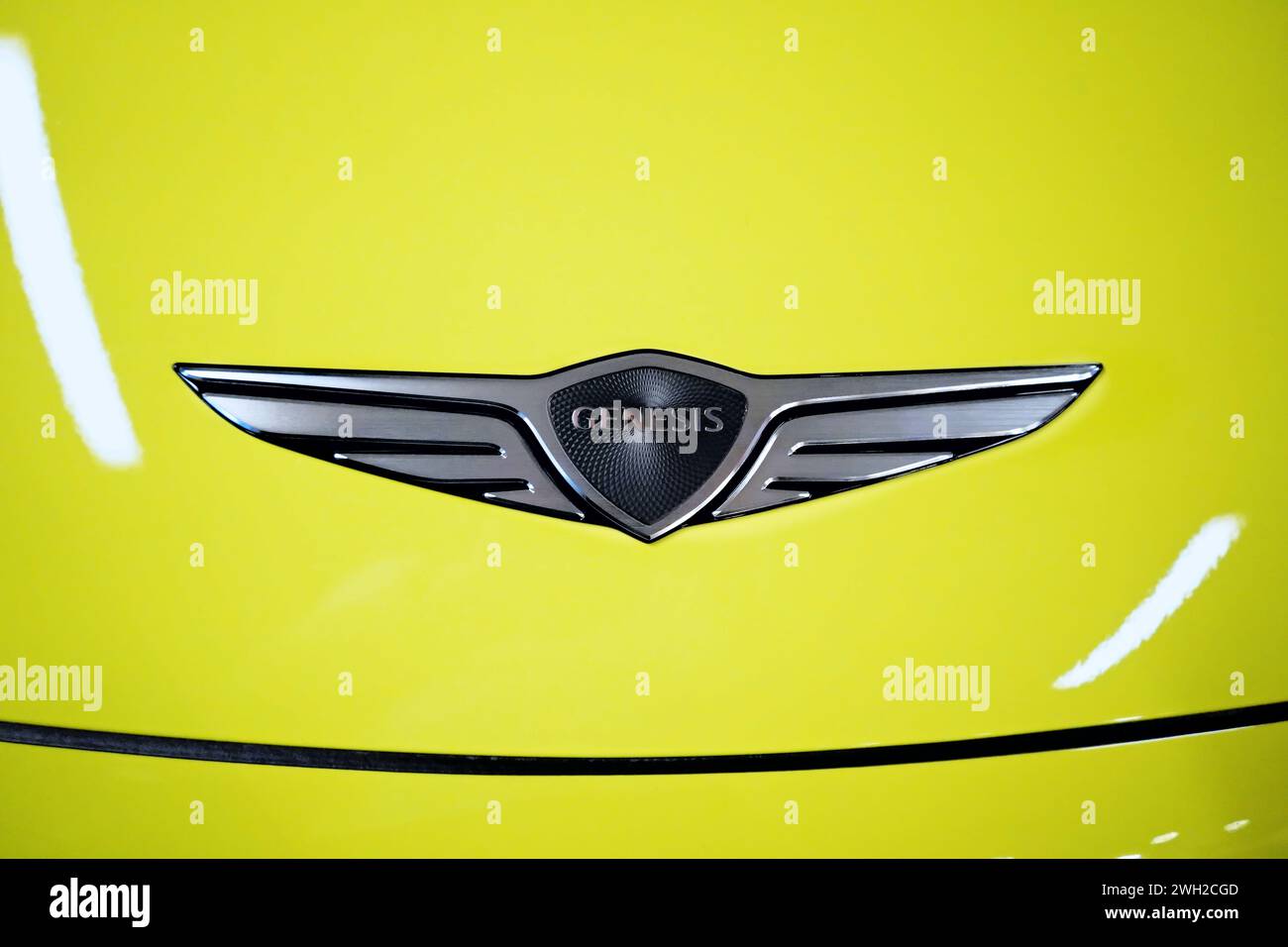 Honolulu, HI - 12 janvier 2024 : Genesis Motor, LLC. Emblème sud-coréen du fabricant de voitures de luxe sur le capot jaune de la voiture Banque D'Images