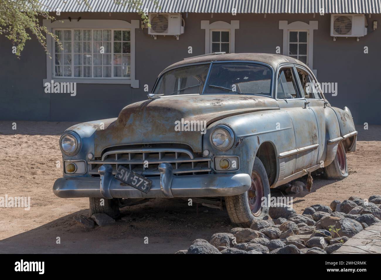 Voiture vintage des années 40 usée par la rouille en exibition à une station-service dans le désert, tourné dans la lumière brillante de fin de printemps à Canyon Roadhouse, Namibie Banque D'Images