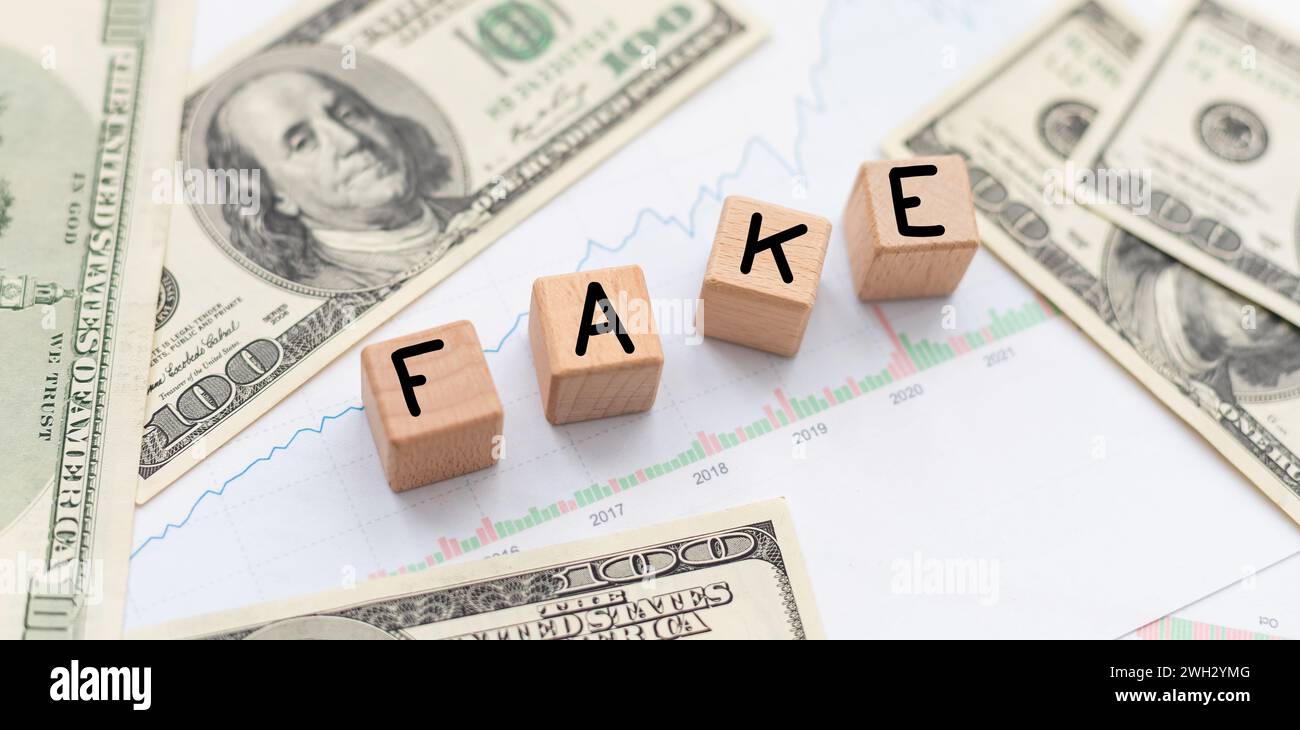 Symbole de fausses nouvelles. Blocs en bois avec des mots de concept fake news sur beau fond de billets de dollar. Concept de médias d'affaires et de fausses nouvelles. Copier Banque D'Images