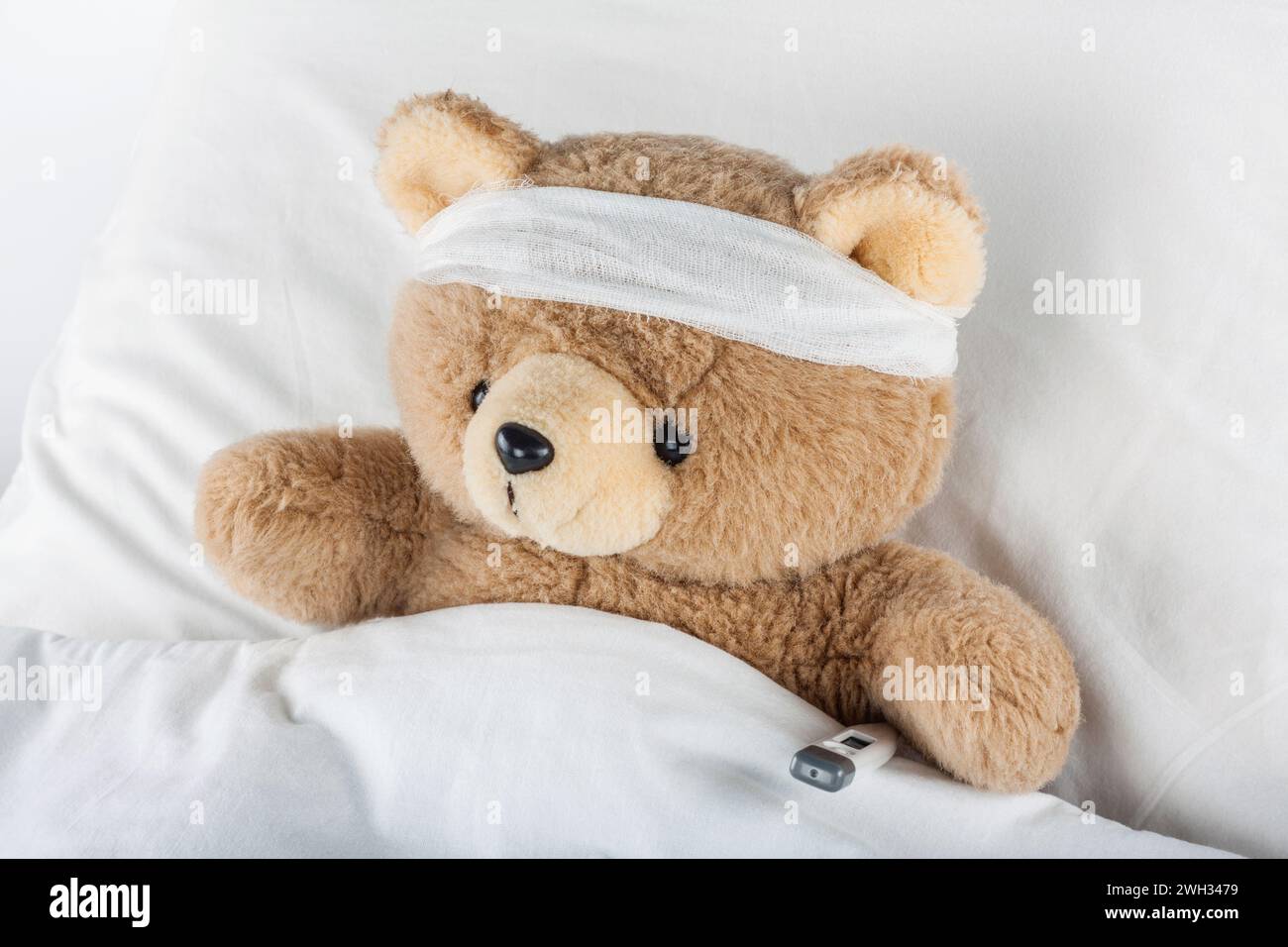 Ours en peluche malade enveloppé dans des bandages Banque D'Images