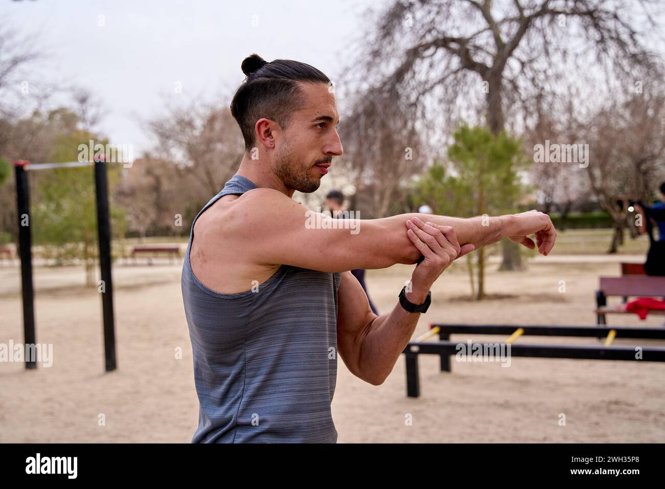 Jeune homme s'étirant dans un parc avant un entraînement dur Banque D'Images