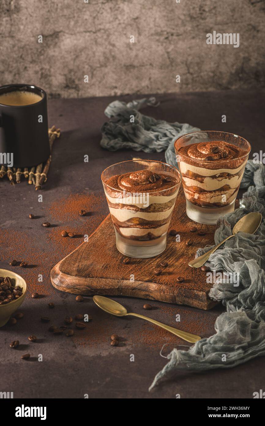 Délicieux dessert italien tiramisu dans un verre sur un fond d'ardoise sombre, de pierre ou de béton. Banque D'Images