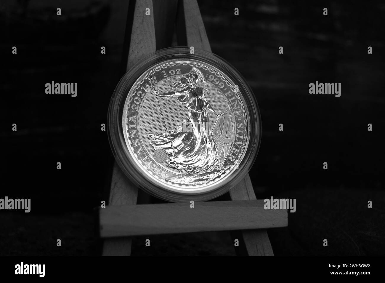 Pièce en argent fin britannique en capsule sur chevalet, photo noir et blanc. 2 livres Britania 1 oz 2021 cose-up. Banque D'Images