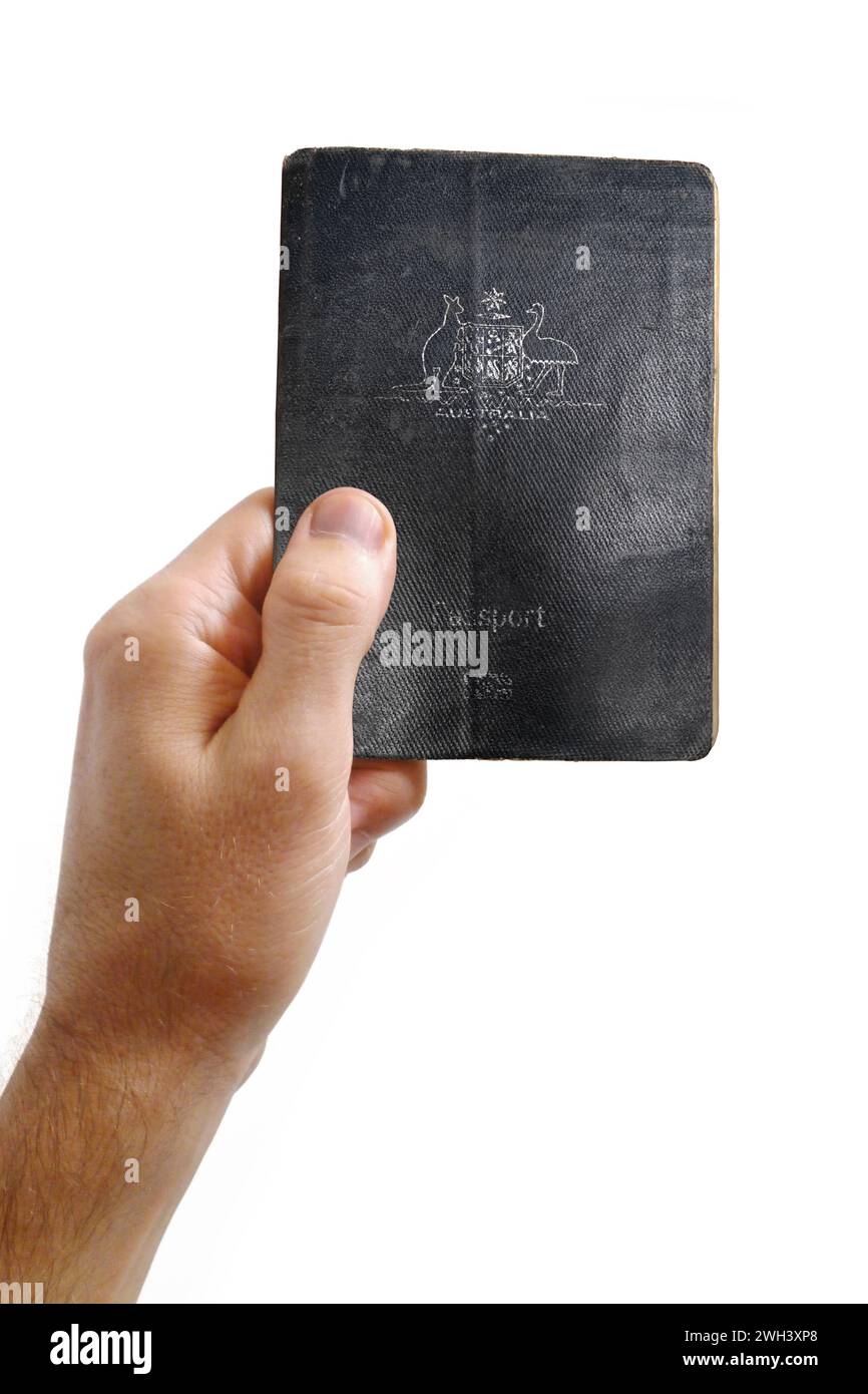 Gros plan sur la main d'un homme tenant un passeport australien sur fond blanc. Banque D'Images