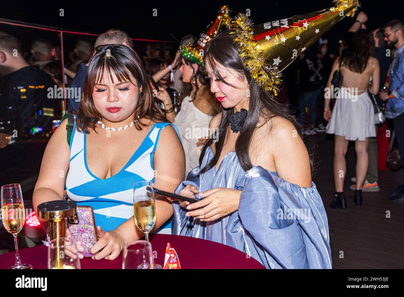 Filles sur le téléphone portable à la fête du nouvel an, Centara Hôtel, Bangkok, Thaïlande Banque D'Images