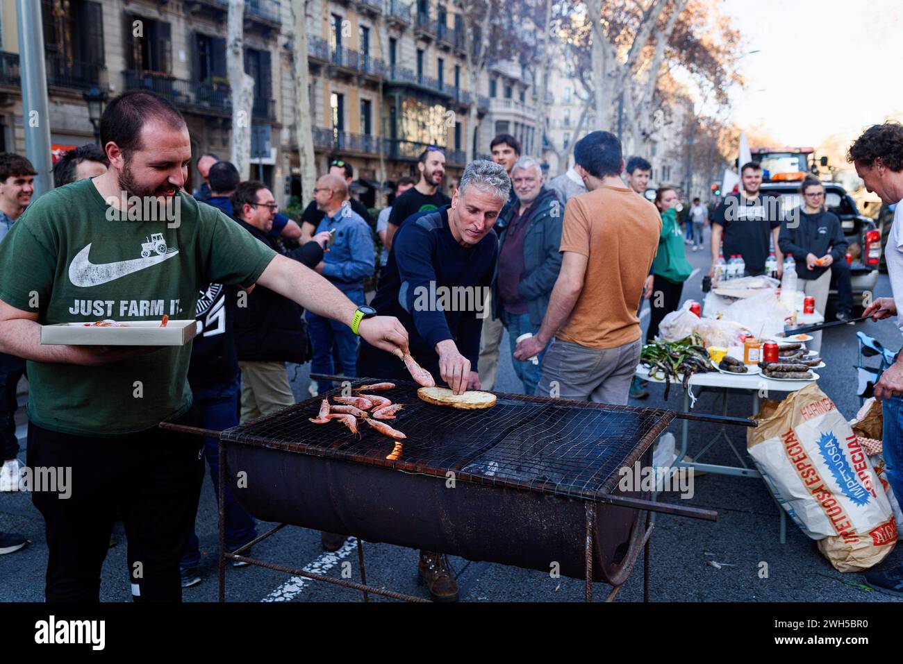 Barcelone, Espagne. 07 février 2024. Des manifestants sont vus cuisiner et manger parmi les tracteurs de l'avenue Gran via pendant la manifestation. Les agriculteurs de toute l'Europe organisent des marches avec leurs tracteurs, bloquent les principales autoroutes et provoquent le chaos dans les centres-villes, protestent et manifestent leur inquiétude face à ce qu'ils considèrent comme des réglementations européennes injustes et restrictives, à la hausse des prix et à la concurrence extérieure à l'Europe. et de faibles rendements ces dernières années en raison du changement climatique. Crédit : SOPA images Limited/Alamy Live News Banque D'Images