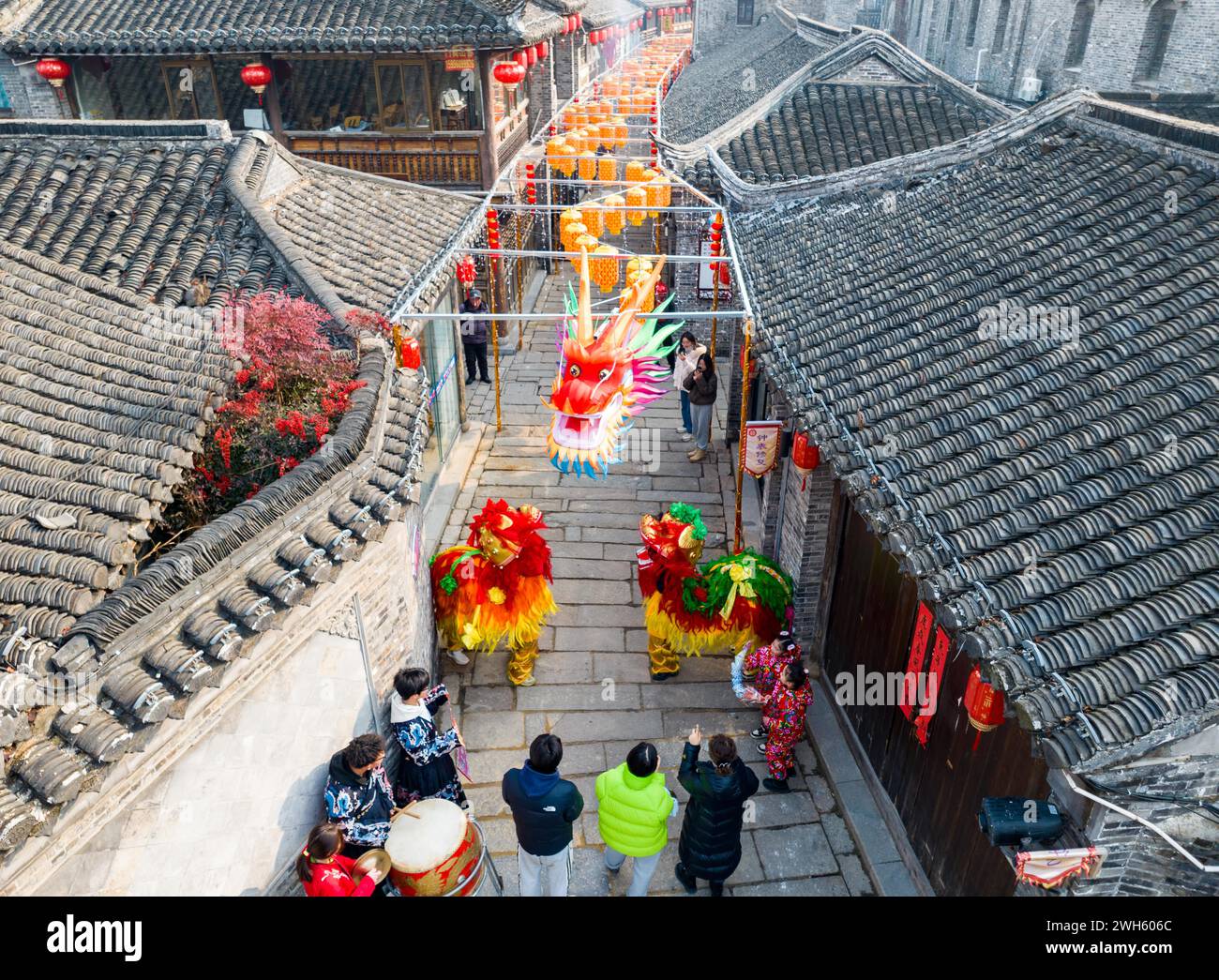 Xingyi, Chine. 08th Feb, 2024. Les touristes regardent un spectacle de danse du lion au quartier de loisirs Baziqiao Cultural Tourism de la rue Zhaoyang à Xinghua, en Chine, le 8 février 2024. (Photo de Costfoto/NurPhoto) crédit : NurPhoto SRL/Alamy Live News Banque D'Images