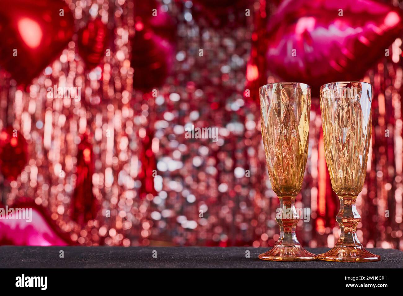 Fond festif pour la saint-valentin avec espace de copie. Bokeh rouge festif de guirlandes, de ballons et de décoration romantique, non focalisé Banque D'Images