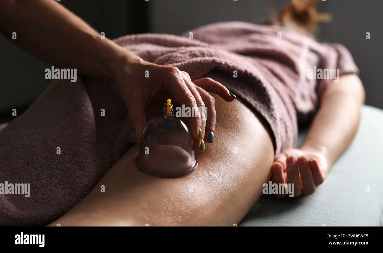 Procédures de réduction de graisse Spa sur les jambes et les fesses avec des tasses sous vide. Procédures de massage sain dans le salon de massage Banque D'Images