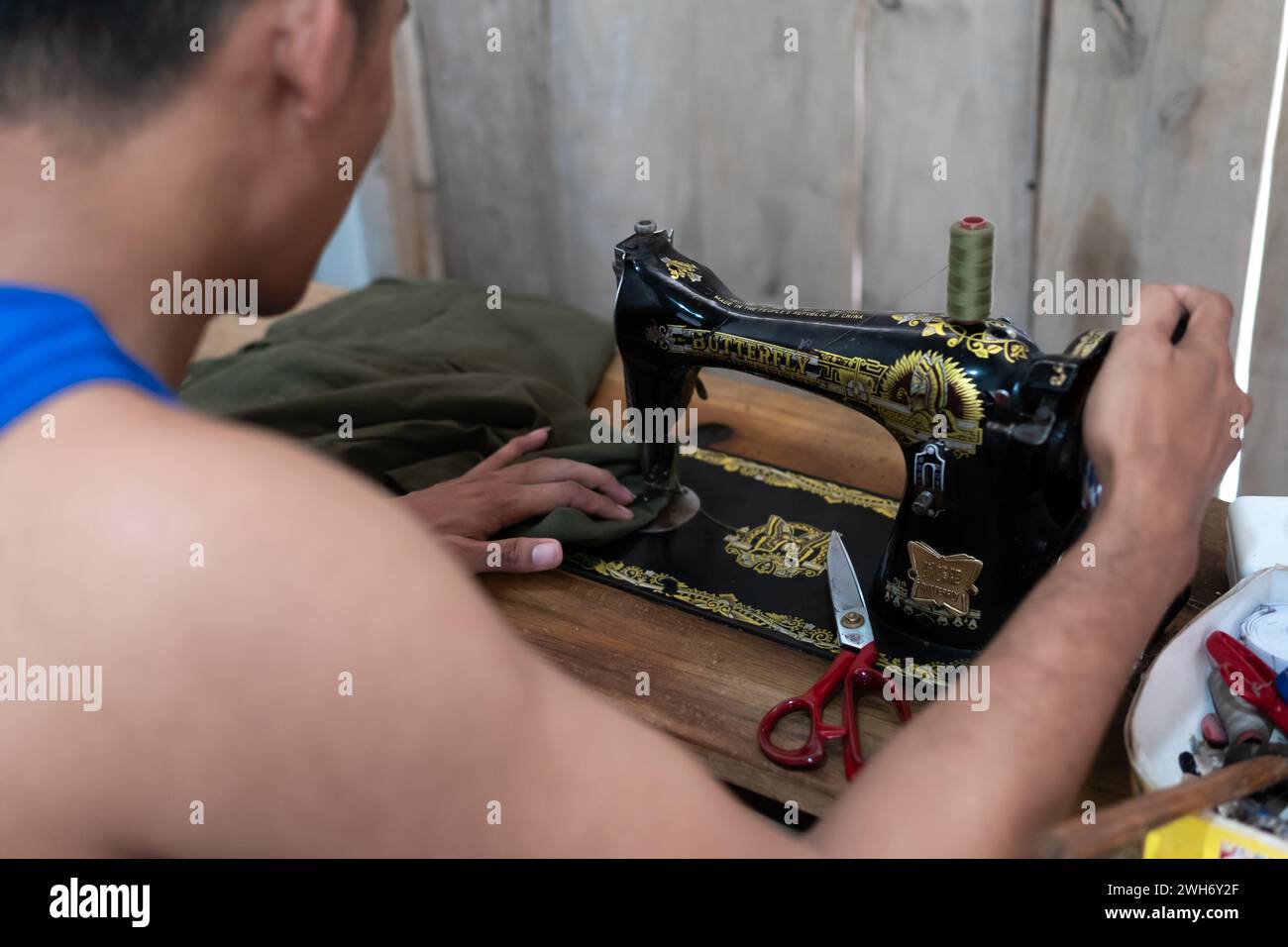 Le tailleur utilise une vieille machine à coudre avec un manuel Banque D'Images