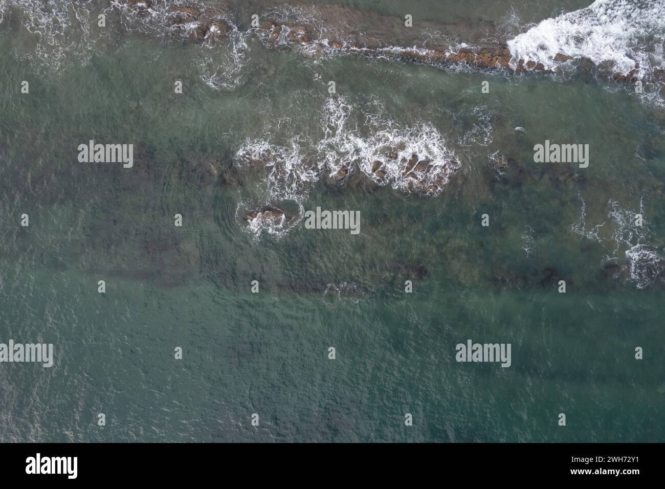 Côte de l'océan avec des roches brunes autour de l'eau de mer verte aérienne au-dessus de la vue de dessus Banque D'Images