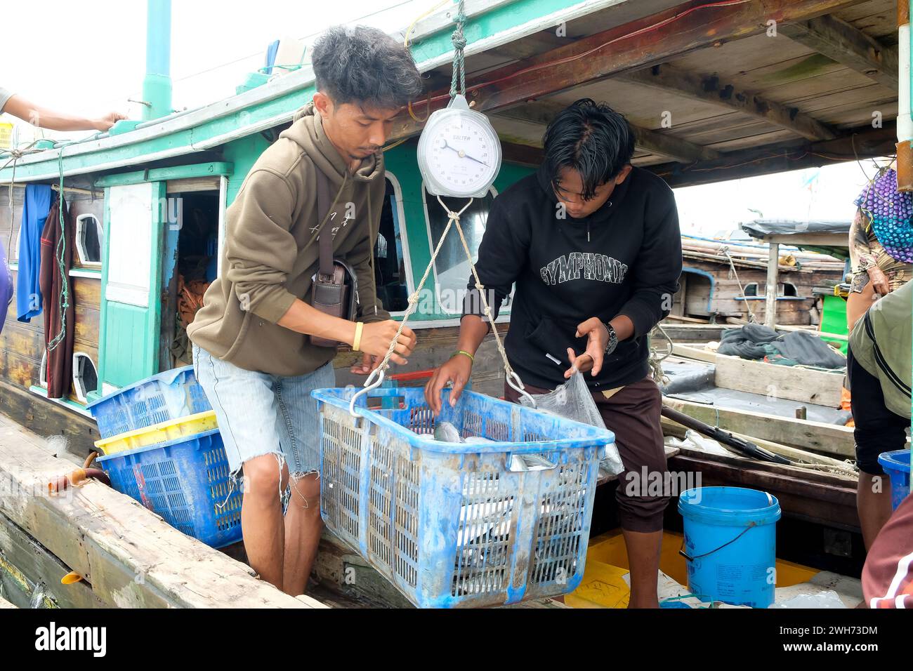 Lampung, Indonésie, 07 octobre 2022 : des pêcheurs ou des membres d'équipage pèsent du poisson dans un panier qui vient d'être capturé sur un bateau Banque D'Images