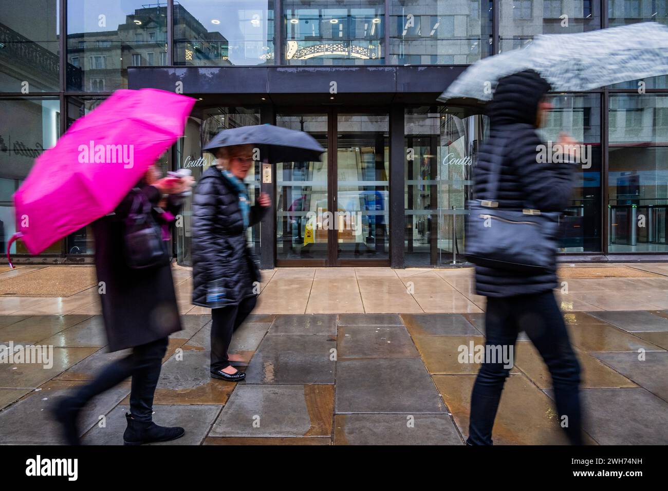 Londres, Royaume-Uni. 8 février 2024. Les gens se protègent de la pluie enveloppée et principalement avec des parapluies lorsqu'ils passent devant la Coutts Bank où NatWest a braconné Emma Crystal, cadre exécutif d'UBS, pour devenir son directeur général après la tempête Nigel Farage - le temps humide et froid du dernier système de tempête arrive à Londres. Crédit : Guy Bell/Alamy Live News Banque D'Images